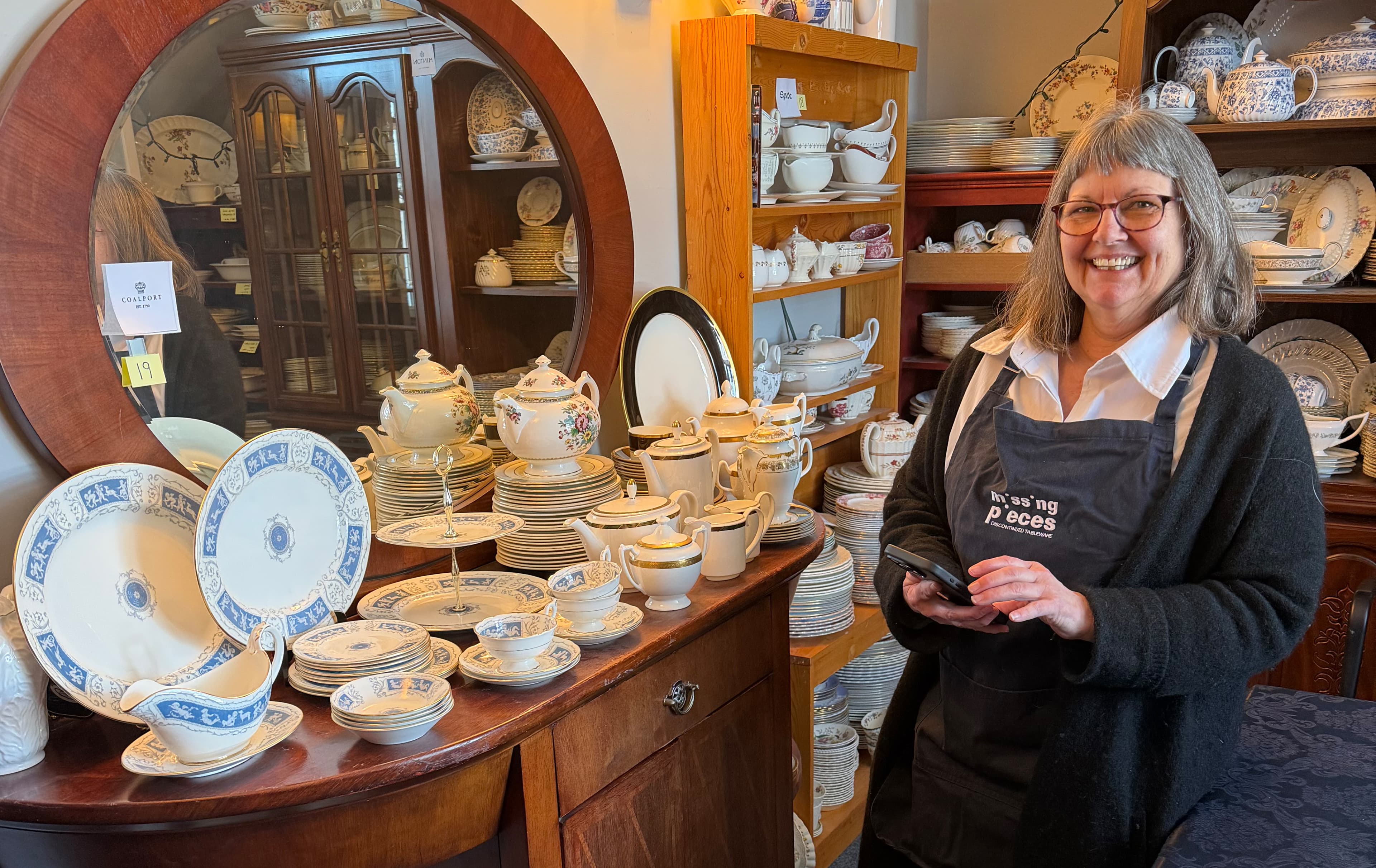 Janice at the counter of her tableware shop reviewing her systems